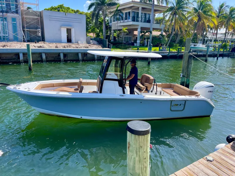 Slide: The Image of 2023 Sea Hunt Ultra 255 SE boat docked in sunny waterfront setting. - 25