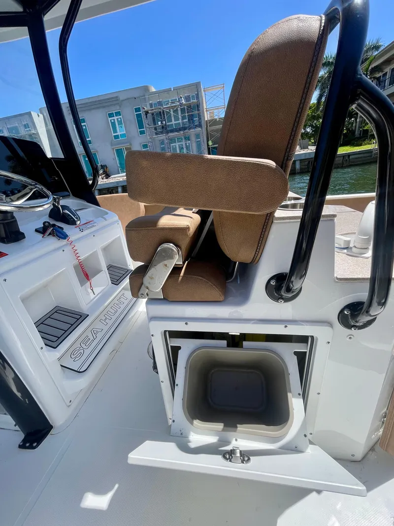 Slide: The Image of 2023 Sea Hunt Ultra 255 SE boat interior with helm seat and storage compartment. - 9