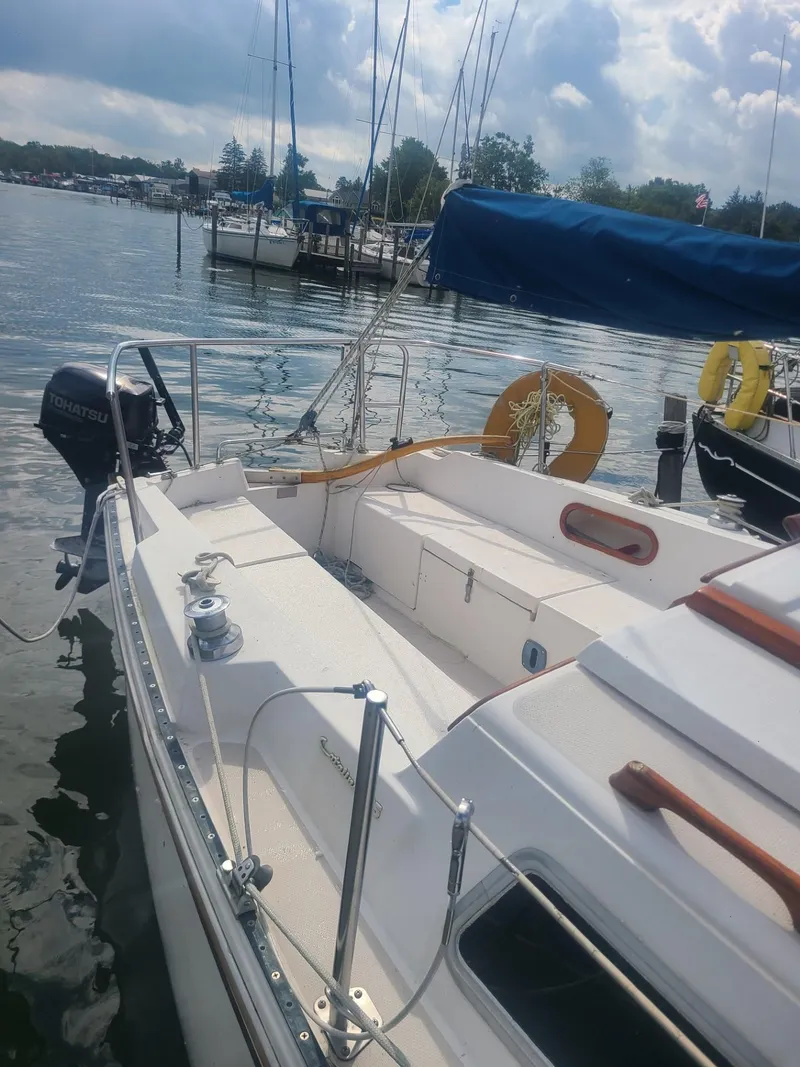 Slide: The Image of 1985 Catalina Fin Keel sailboat docked on a calm lake under a cloudy sky. - 3