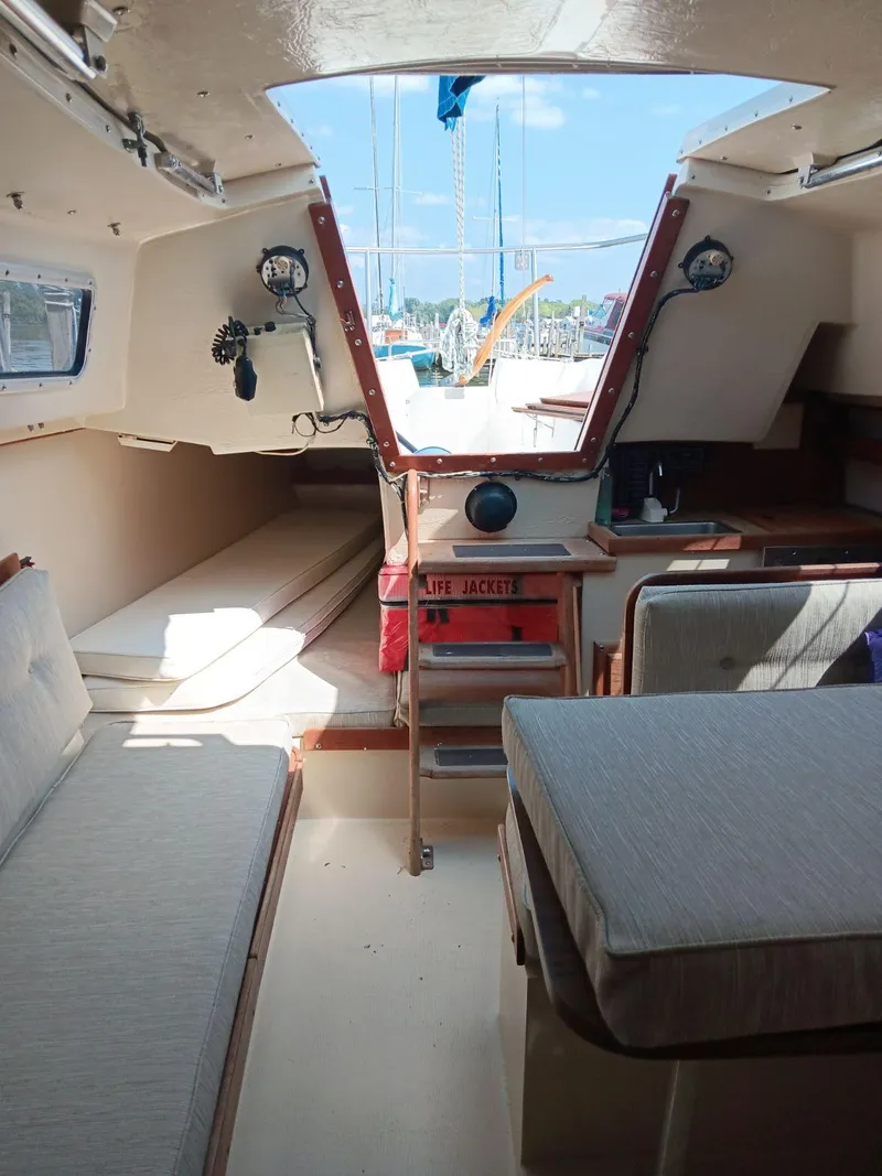 Slide: The Image of Interior of a 1985 Catalina Fin Keel sailboat, featuring seating and a life jacket storage. - 5