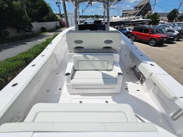 Slide: The Image of 2026 Southport 30FE boat interior with white seating and table in a warehouse setting. - 11