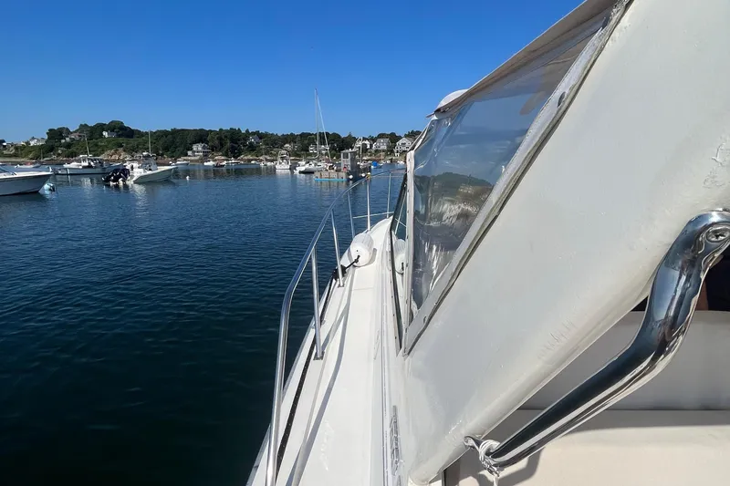 Slide: The Image of 1990 Tiara Yachts 3100 on calm water, marina in background. - 12