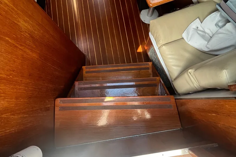 Slide: The Image of Interior wooden stairs of 1990 Tiara Yachts 3100, featuring polished finish and leather seating. - 13