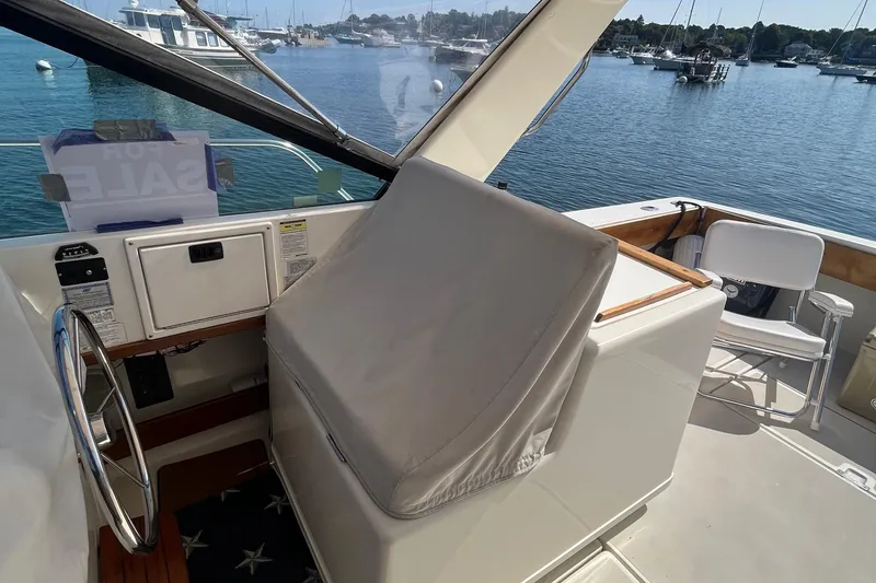 Slide: The Image of 1990 Tiara Yachts 3100 helm with covered controls, overlooking marina. - 15