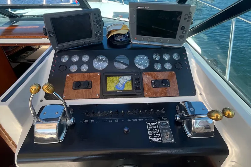 Slide: The Image of 1990 Tiara Yachts 3100 helm with navigation screens and controls. - 18