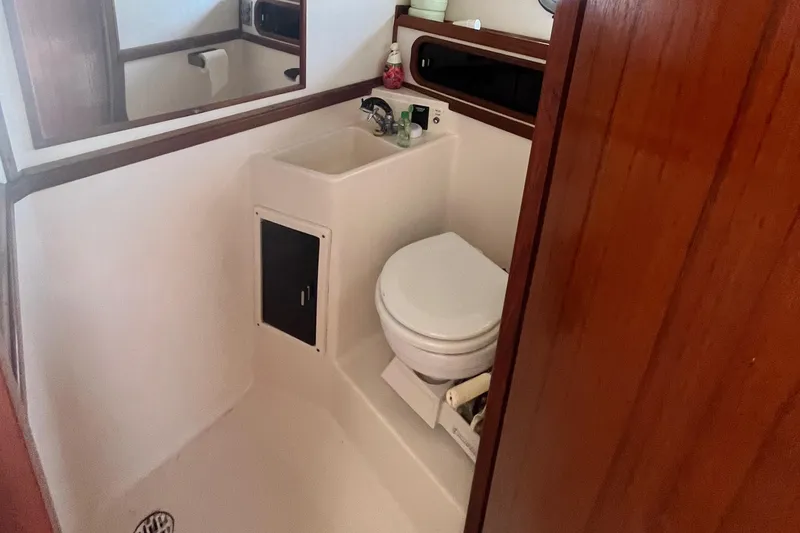 Slide: The Image of 1990 Tiara Yachts 3100 bathroom with toilet, sink, and wooden accents. - 19