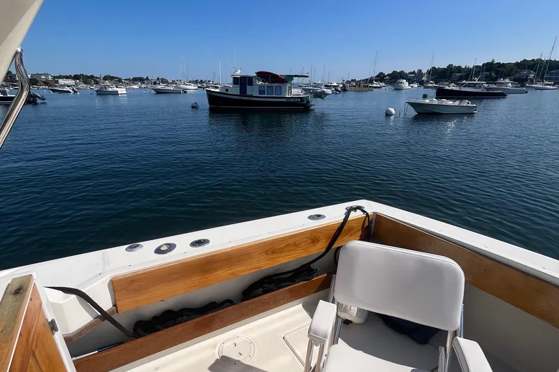 Slide: The Image of 1990 Tiara Yachts 3100 on calm water with scenic harbor view. - 7