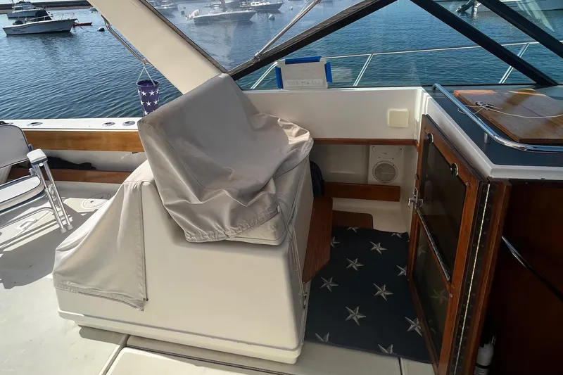 Slide: The Image of 1990 Tiara Yachts 3100 interior with covered seating and star-patterned rug. - 9