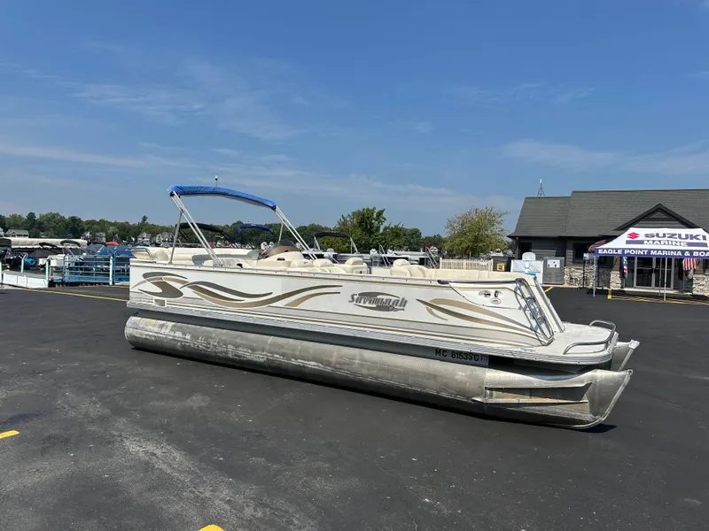 Slide: The Image of 2002 Crest Savannah pontoon boat with blue canopy in marina parking lot. - 0