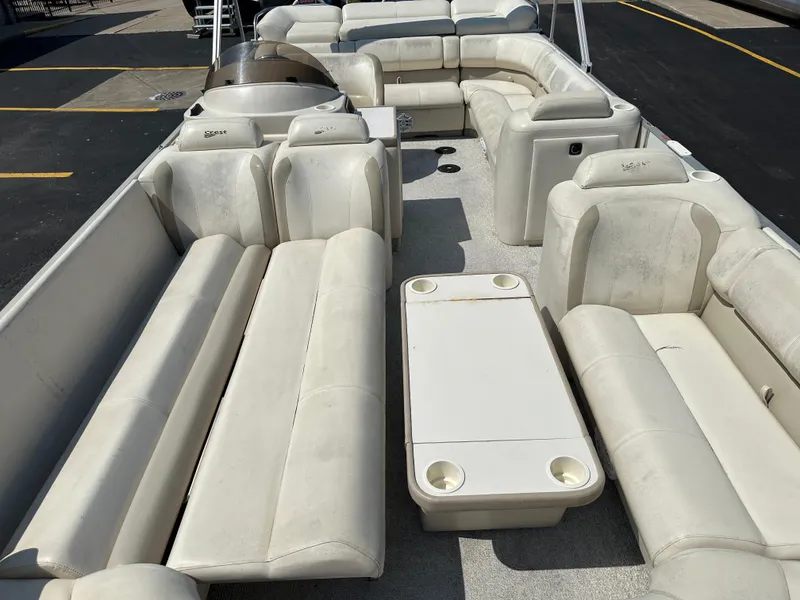 Slide: The Image of 2002 Crest Savannah pontoon boat with spacious seating and table, ideal for leisure activities. - 11