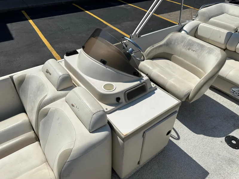 Slide: The Image of 2002 Crest Savannah boat interior with white seating and steering console. - 13