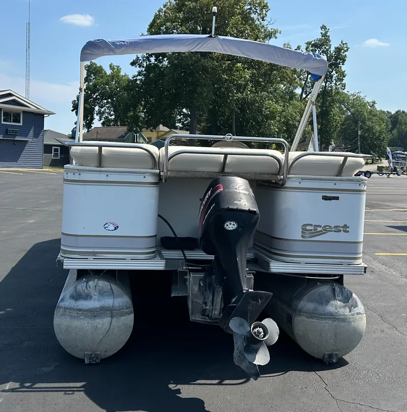 Slide: The Image of 2002 Crest Savannah pontoon boat with canopy and outboard motor in a parking lot. - 4