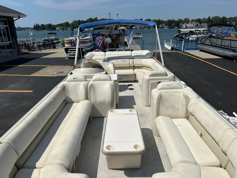 Slide: The Image of 2002 Crest Savannah pontoon boat with spacious seating and canopy, docked by a scenic lake. - 8