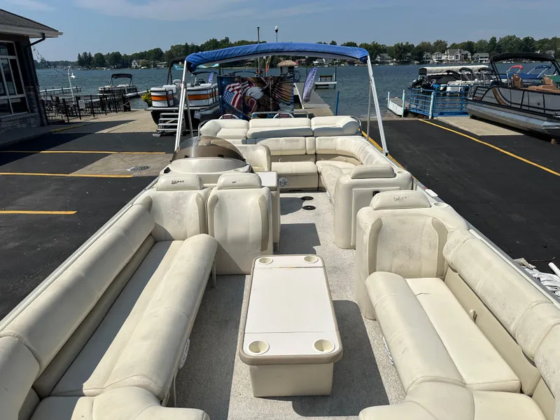 Slide: The Image of 2002 Crest Savannah pontoon boat with spacious seating, docked by a scenic lake. - 9