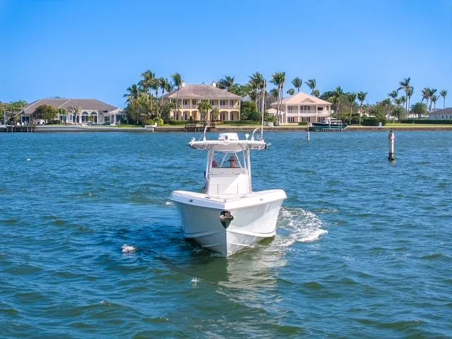 Slide: The Image of 2007 Spectre 37 Center Console boat cruising on a sunny day near waterfront homes. - 13