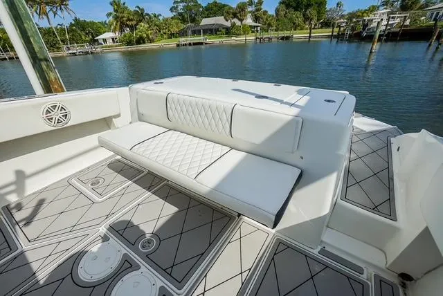 Slide: The Image of 2007 Spectre 37 Center Console boat with white seating and scenic waterfront view. - 27