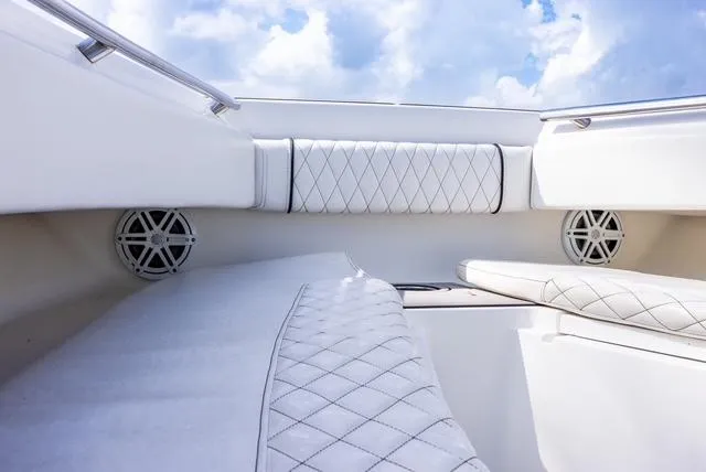 Slide: The Image of 2007 Spectre 37 Center Console boat interior with white quilted seating and speakers. - 28
