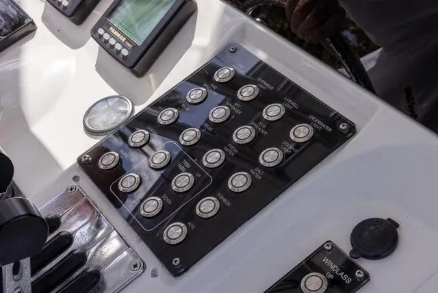 Slide: The Image of Control panel of a 2007 Spectre 37 Center Console boat with various switches and displays. - 32