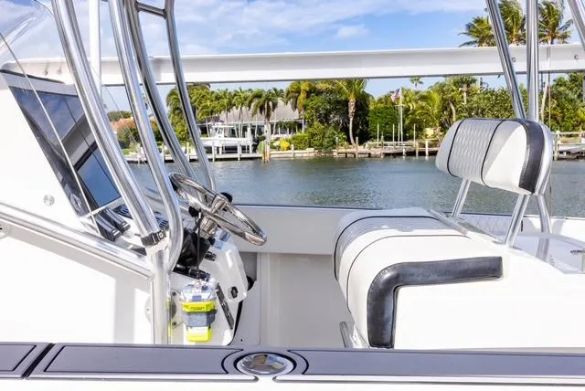 Slide: The Image of 2007 Spectre 37 Center Console boat interior with steering wheel and seating, near waterfront homes. - 38