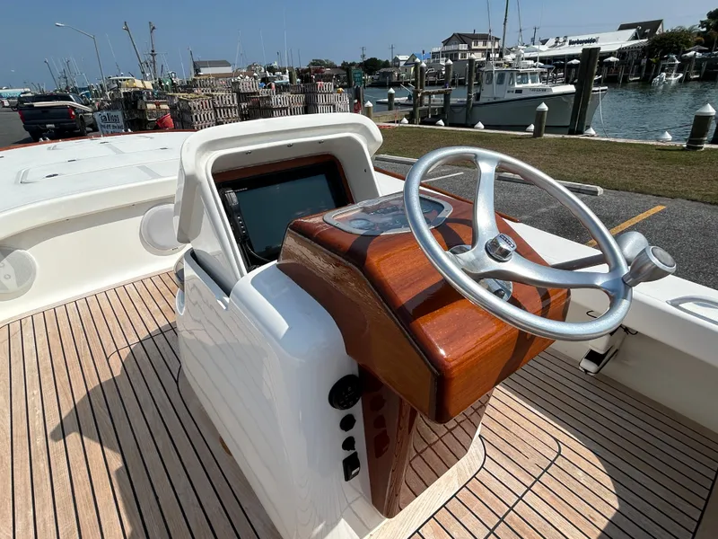 Slide: The Image of 2002 Bayshore Carolina Flats 20 boat helm with wooden dashboard and steering wheel. - 13