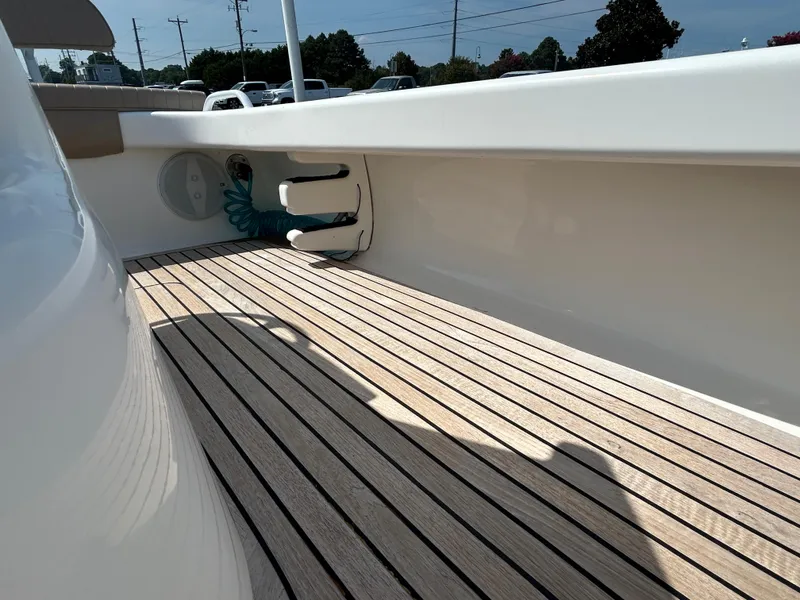 Slide: The Image of 2002 Bayshore Carolina Flats 20 boat deck with wood finish and clean white sides. - 20