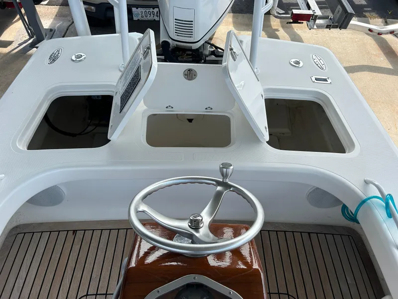 Slide: The Image of 2002 Bayshore Carolina Flats 20 boat interior with open storage compartments and steering wheel. - 28