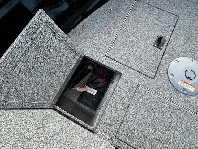 Slide: The Image of 2025 Crestliner 1650 Kodiak boat deck with open storage compartment and visible wiring. - 18