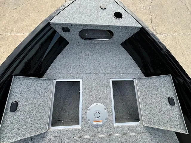 Slide: The Image of 2025 Crestliner 1650 Kodiak boat interior with storage compartments and gray carpeted deck. - 19