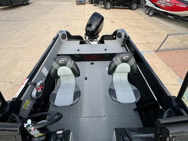 Slide: The Image of 2025 Crestliner 1650 Kodiak boat interior with two seats and motor, parked on concrete. - 21