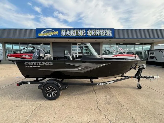 Slide: The Image of 2025 Crestliner 1650 Kodiak boat on trailer outside marine center, under cloudy sky. - 5