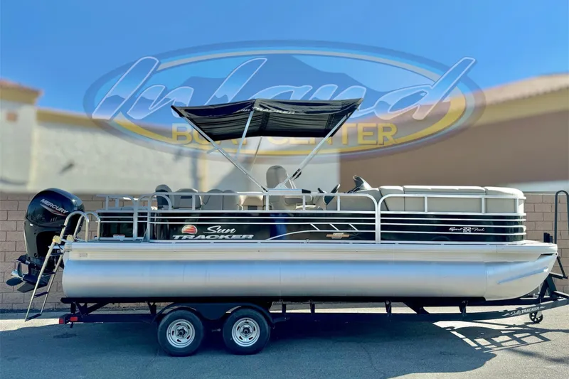 The Image of 2023 Sun Tracker SportFish 22 DLX pontoon boat on trailer, outdoor display. - 0