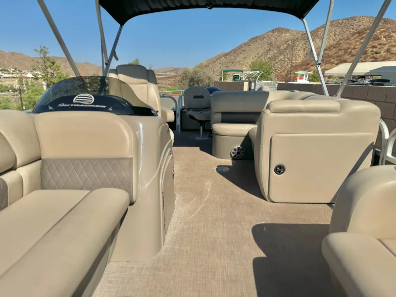 Slide: The Image of 2023 Sun Tracker Sport Fish 22 DLX pontoon boat interior with beige seating and canopy. - 10