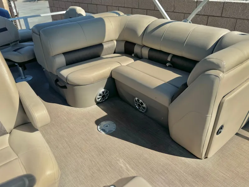 Slide: The Image of 2023 Sun Tracker Sport Fish 22 DLX boat interior with beige seating and built-in speakers. - 11