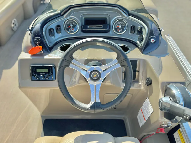 Slide: The Image of 2023 Sun Tracker Sport Fish 22 DLX dashboard with steering wheel and controls. - 22