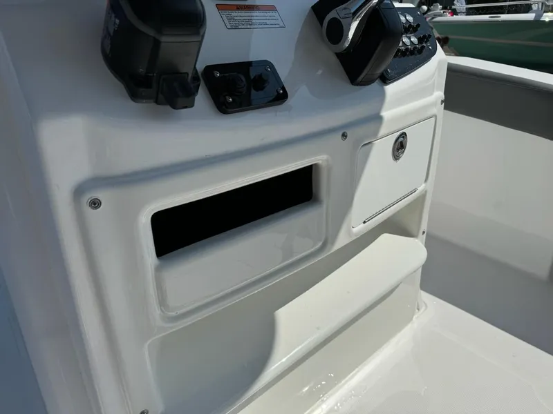 Slide: The Image of Control panel of 2025 NauticStar 242L Offshore boat, featuring storage compartments. - 10