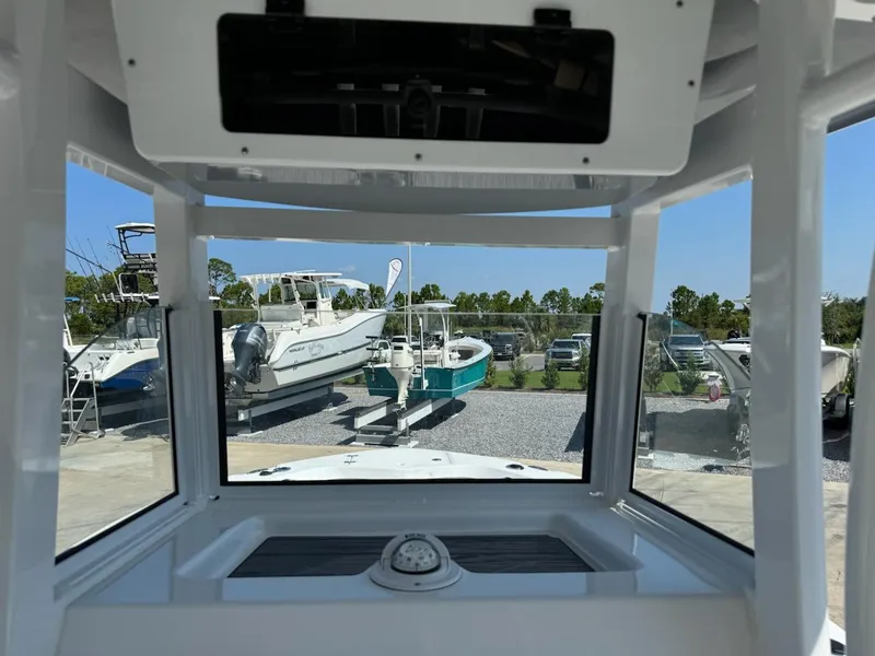 Slide: The Image of 2025 NauticStar 242L Offshore boat interior view with clear windows and outdoor boats. - 11
