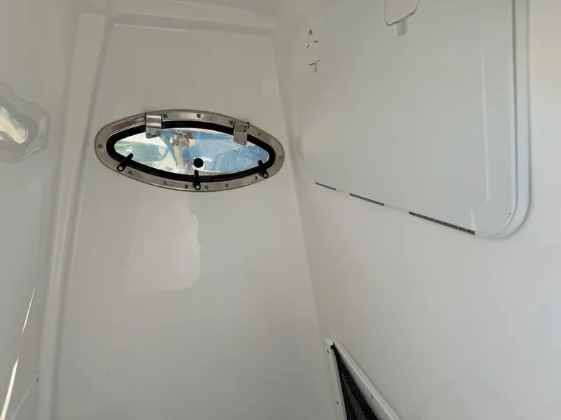 Slide: The Image of Interior cabin view of 2025 NauticStar 242L Offshore boat with oval window. - 12