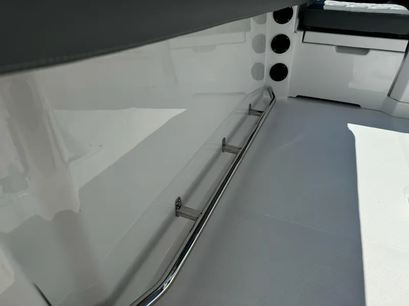 Slide: The Image of 2025 NauticStar 242L Offshore boat interior with sleek design and stainless steel railing. - 17