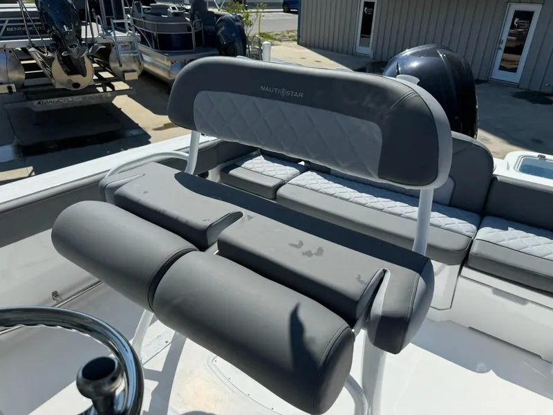 Slide: The Image of 2025 NauticStar 242L Offshore boat seating with gray upholstery and steering wheel. - 18