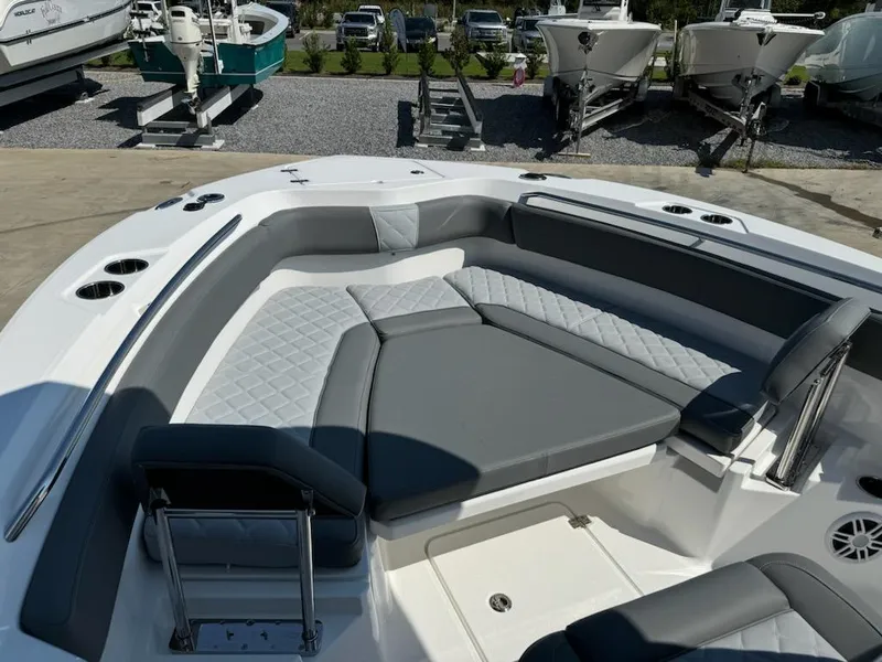 Slide: The Image of 2025 NauticStar 242L Offshore boat with spacious seating and modern design in a marina setting. - 22