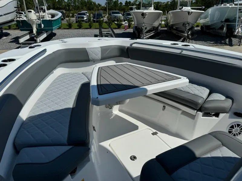 Slide: The Image of 2025 NauticStar 242L Offshore boat interior with cushioned seating and table. - 27