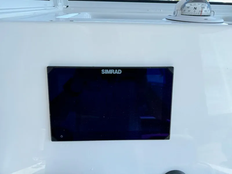 Slide: The Image of Simrad display on 2025 NauticStar 242L Offshore boat dashboard with compass. - 9