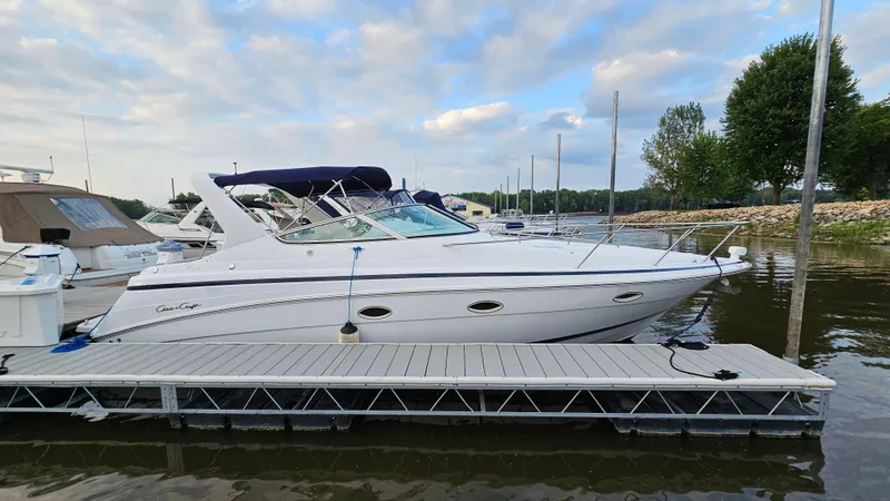 The Image of 2000 Chris-Craft 328 Express Cruiser docked at marina under partly cloudy sky. - 1