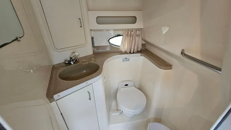 Slide: The Image of 2000 Chris-Craft 328 Express Cruiser bathroom with sink, toilet, and storage cabinets. - 23