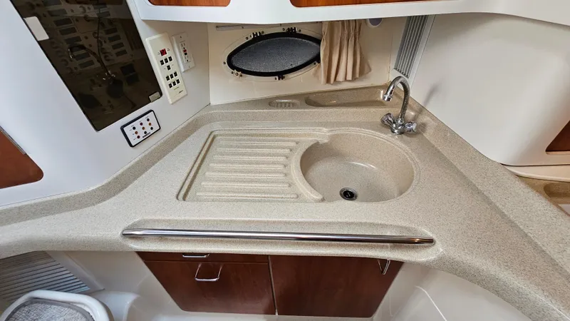 Slide: The Image of 2000 Chris-Craft 328 Express Cruiser kitchen area with sink and countertop. - 25
