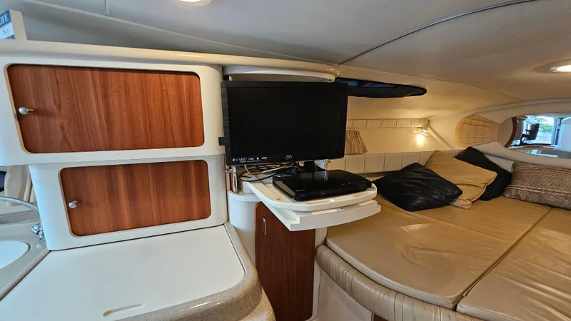 Slide: The Image of 2000 Chris-Craft 328 Express Cruiser interior with TV, cabinets, and cozy seating area. - 28
