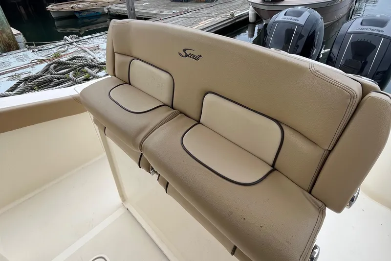 Slide: The Image of 2018 Scout 255 LXF boat seat with beige upholstery at a dock. - 13