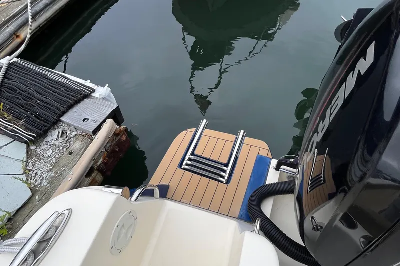 Slide: The Image of 2018 Scout 255 LXF boat with teak swim platform and Mercury outboard engine. - 15