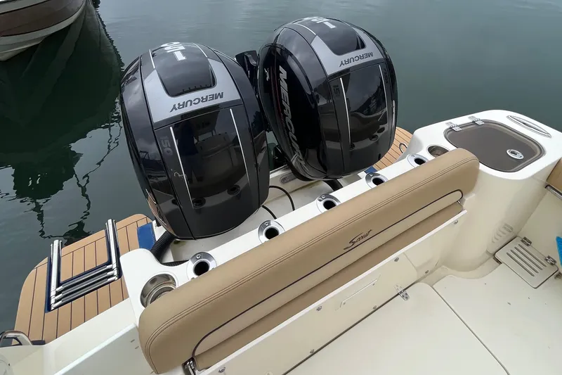 Slide: The Image of 2018 Scout 255 LXF boat with dual Mercury engines, docked on calm water. - 4
