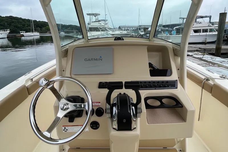 Slide: The Image of 2018 Scout 255 LXF boat dashboard with Garmin navigation, docked at marina. - 6